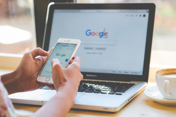 shutterstock-person-on-computer-and-phone-googling